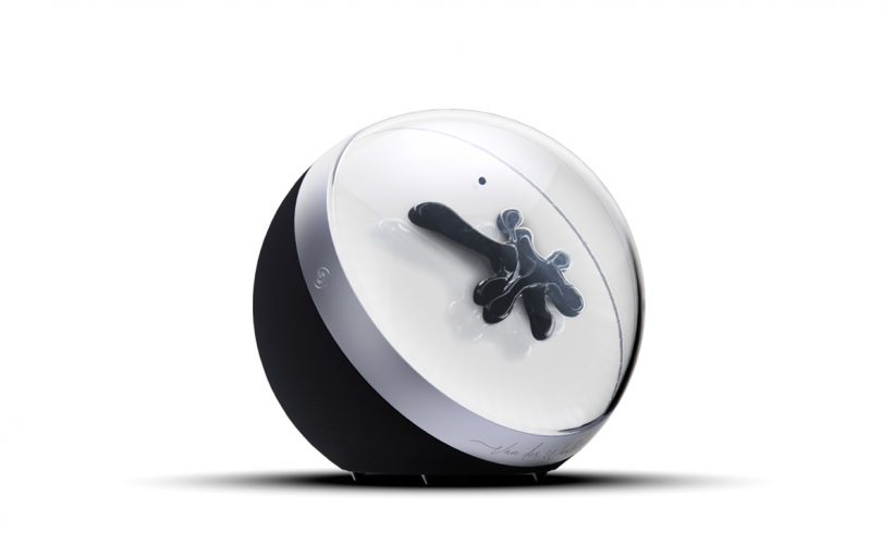 Spherical audio speaker with black half and clear front display with ferrofluid inside.