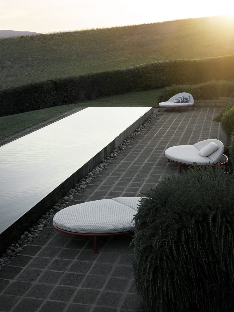 three outdoor loungers around an elongated pool