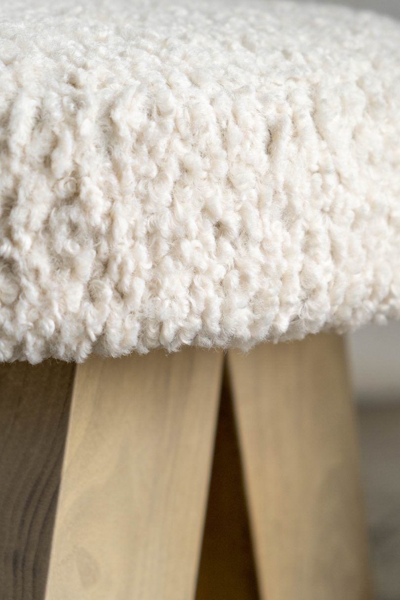 detail of light wood chair with sherpa upholstery