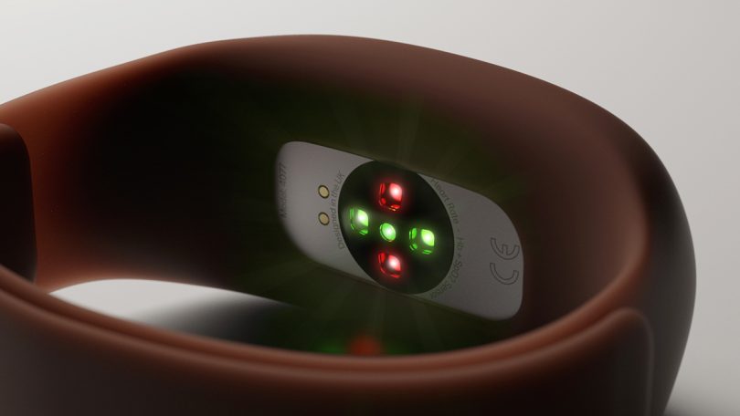Underside of Dip oximeter sensor set in silicone wristband with red and green lights illuminated.