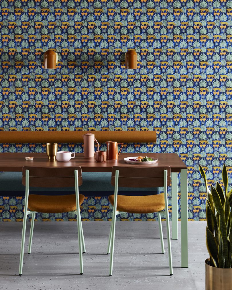 dining space with table, chairs, and patterned wallpaper