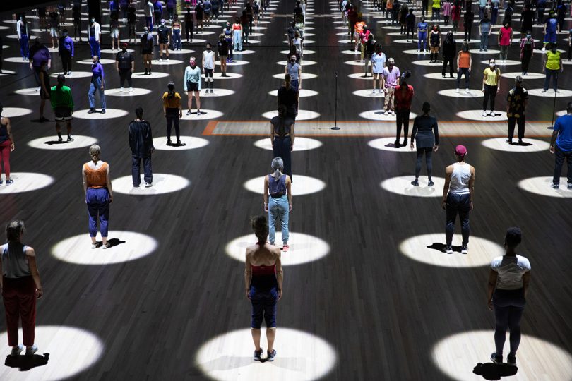 art installation with individuals standing in pools of iight