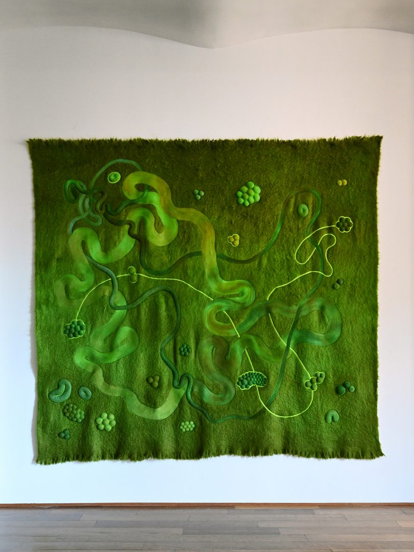 green textile art hanging on wall