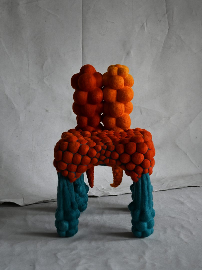 orange and teal abstract chair with grey background