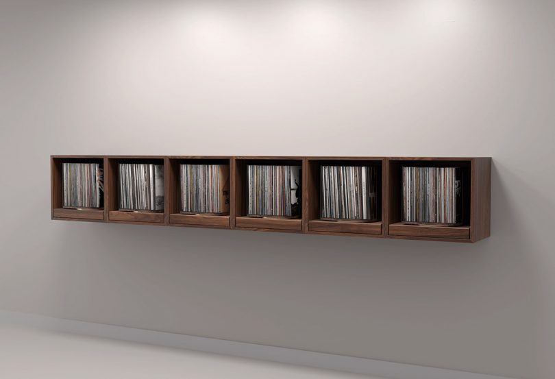 Six rpm record storage units in walnut finish wall mounted side-by-side as one continual display.