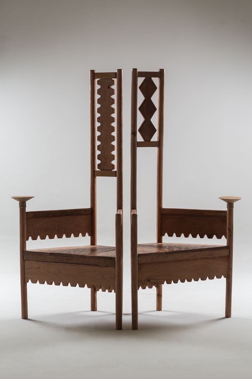 two dark wood chairs with high backs