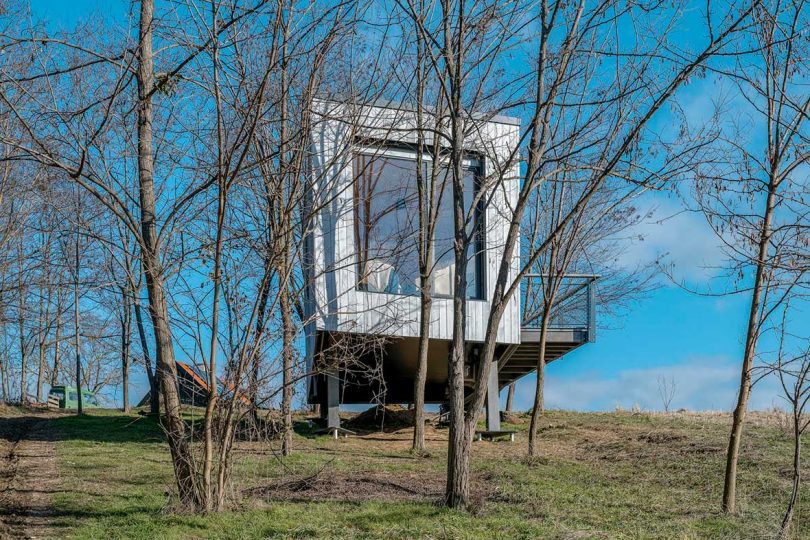 exterior view of modern tiny cabin on stilts