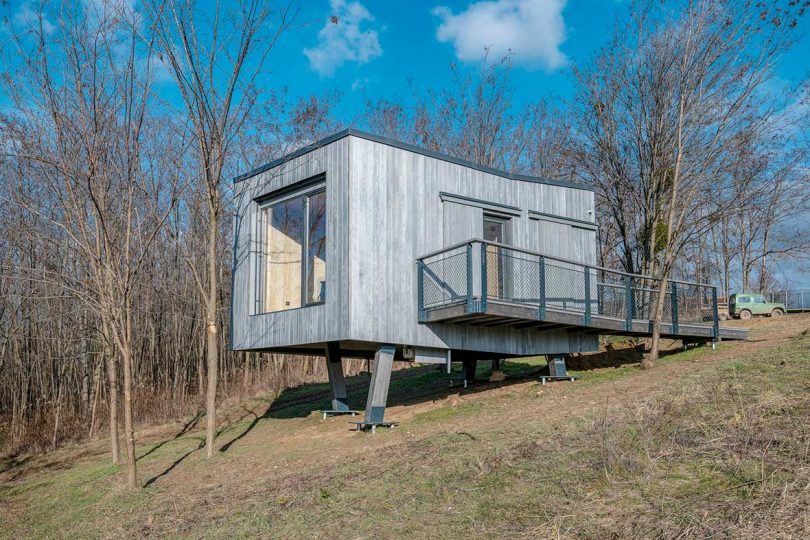 side exterior view of modern tiny cabin on stilts