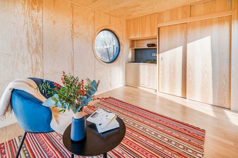 corner interior view of tiny cabin with wood panel walls and small kitchenette