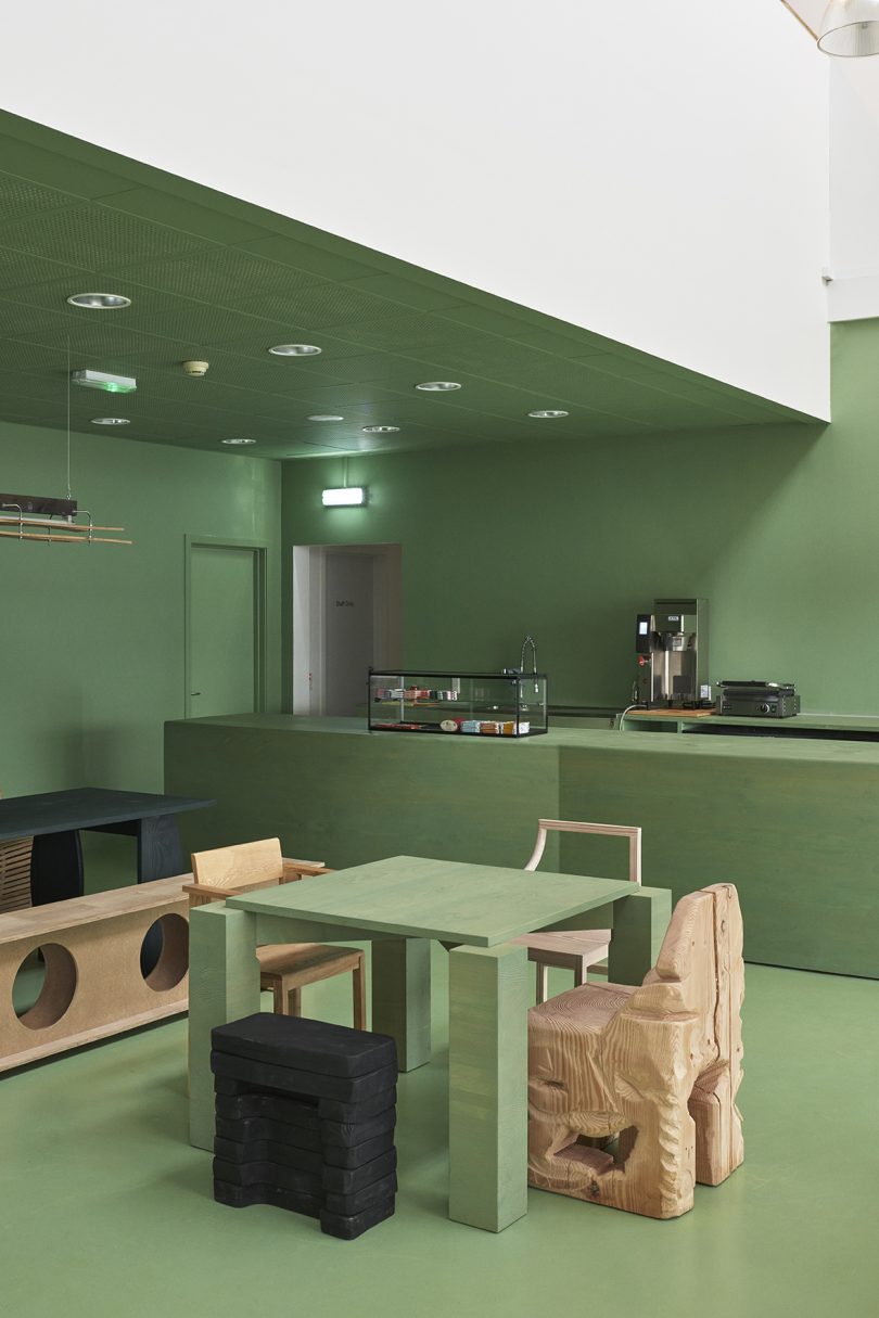 olive green cafe space with wood furniture