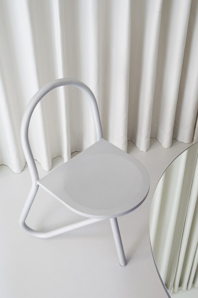 tubular chair in front of white pleated background
