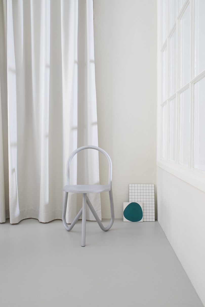 tubular chair in front of white pleated background