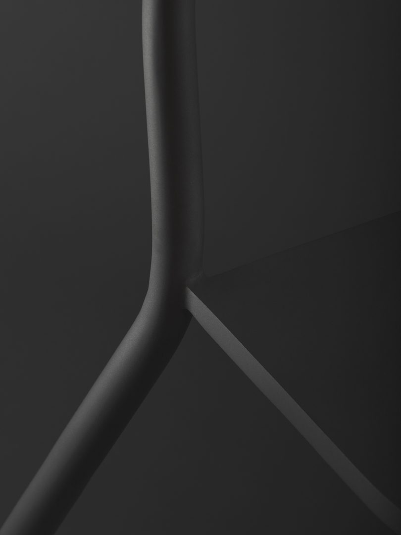 detail of black tubular chair against black background