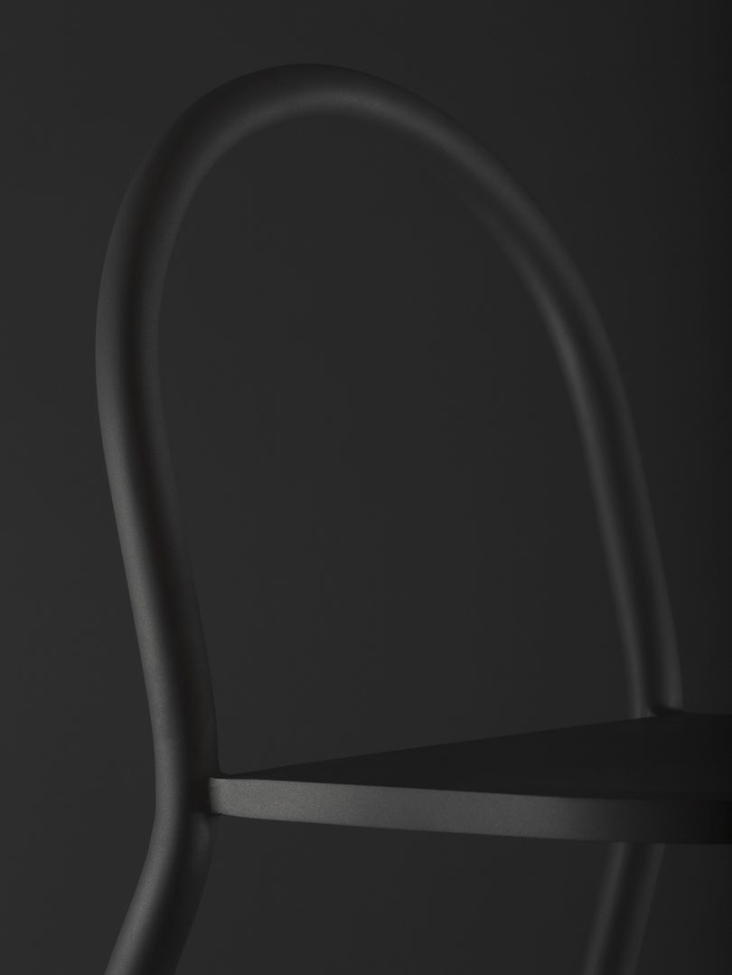 detail of black tubular chair against black background