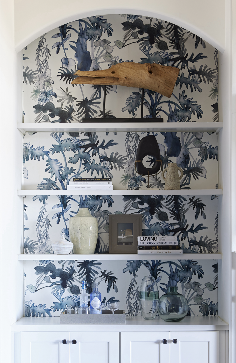 built-in cabinet with wallpaper featuring abstract leaves
