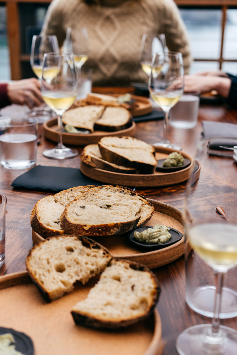 dining table filled with plates of bread and wine glasses