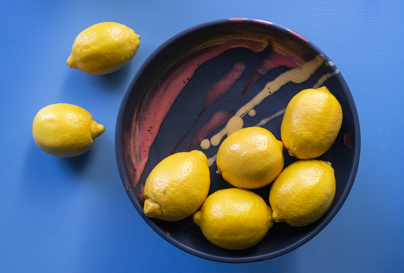 overhead view of marbled ceramic bowl with lemons