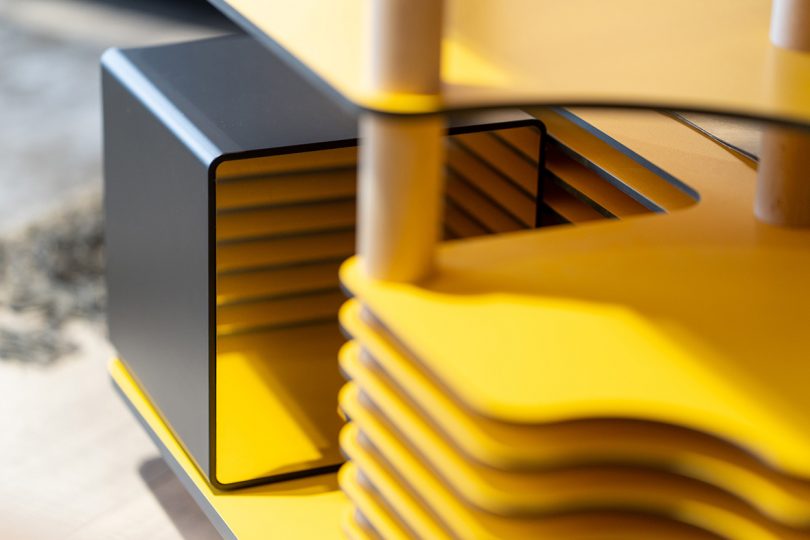 Detail of bright yellow horizontal slot storage for records on trolly.