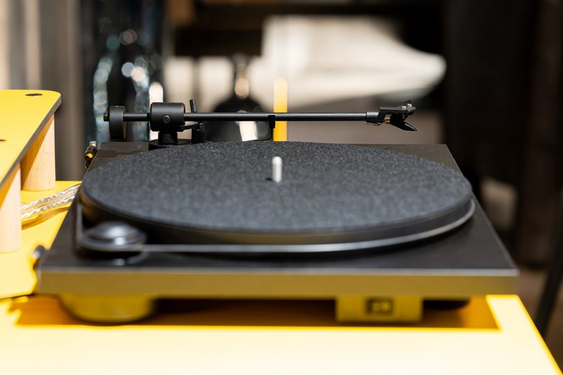 Side view of black turntable on yellow laminate top.