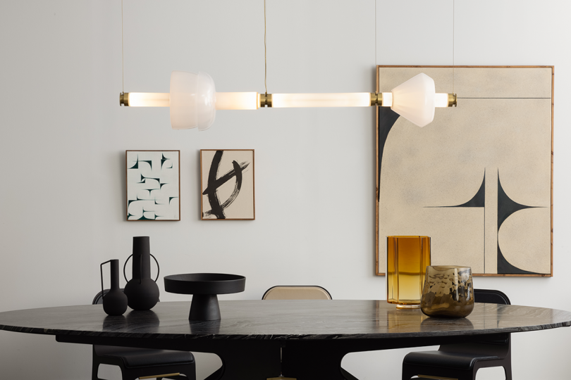 horizontal lit pendant light hanging over a dining table