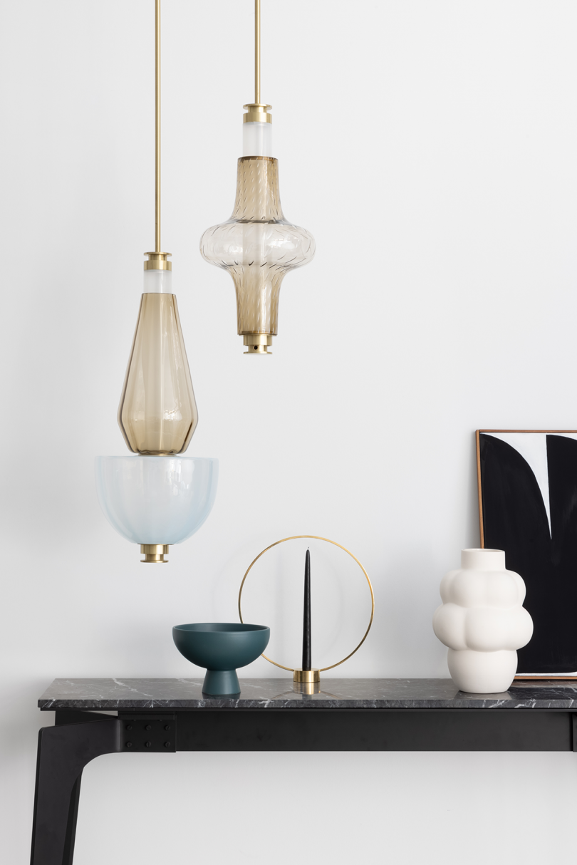 two unlit light pendants hanging above styled console table