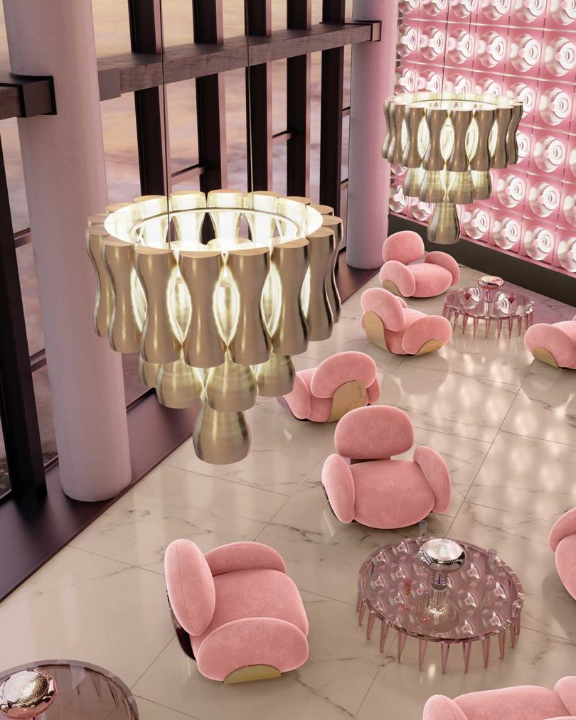 overhead photo of pink armchairs, lucite coffee tables, and white chandeliers