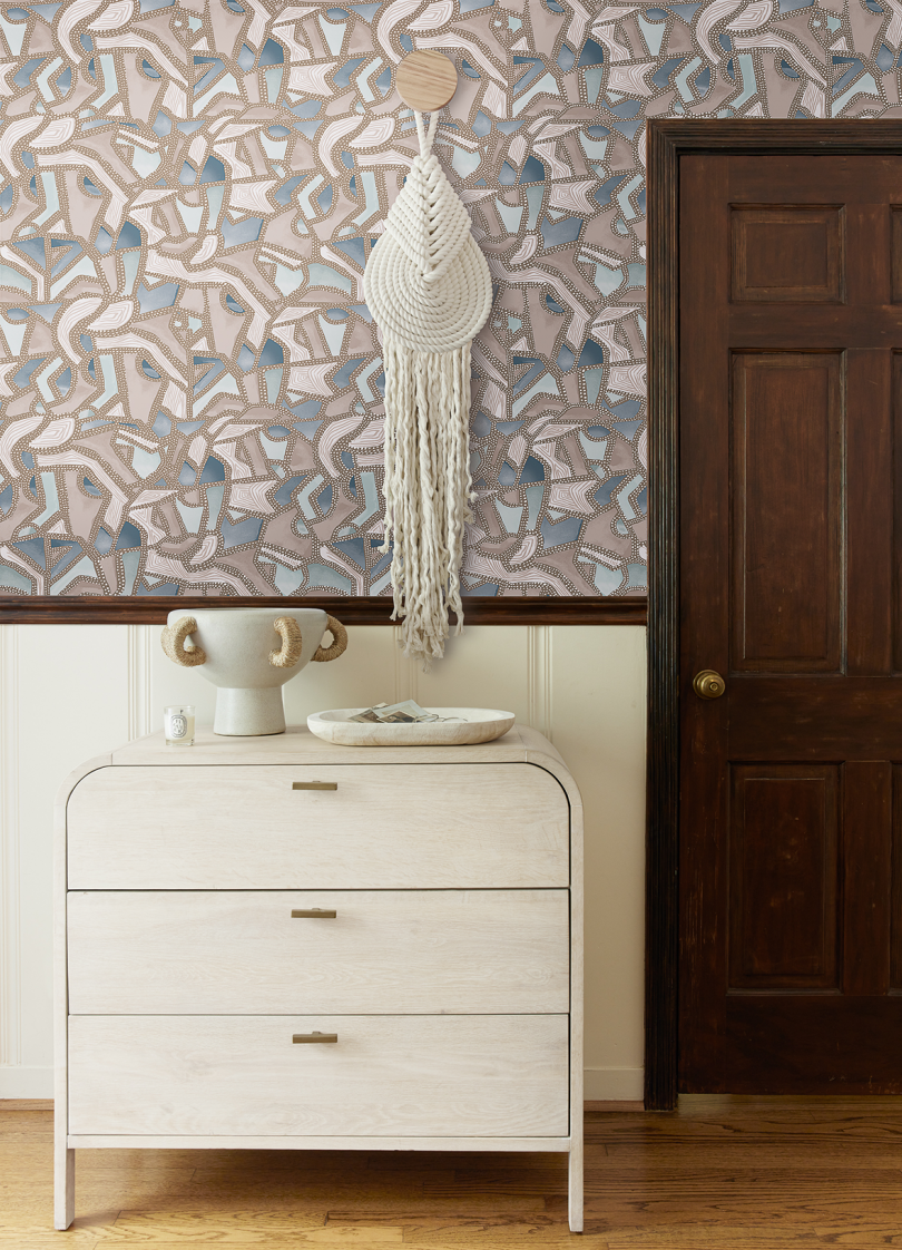 blue and brown patterned wallpaper on half wall behind dresser