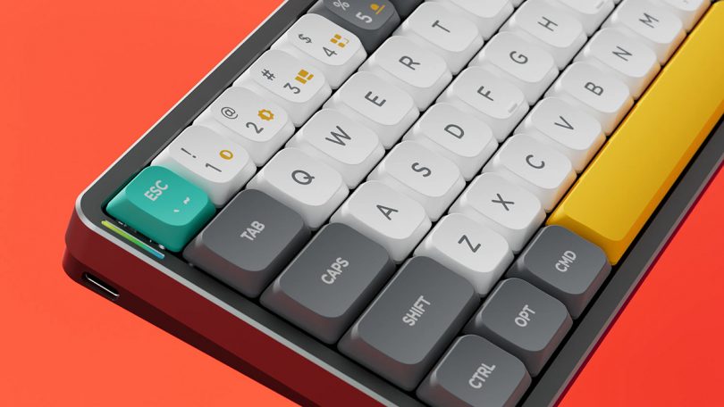 Angled view of Air60's left side keycaps, including yellow icons for multimedia controls and aqua ESC key.