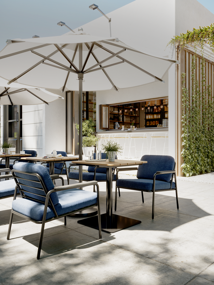 four indoor/outdoor armchairs around a table under and umbrella