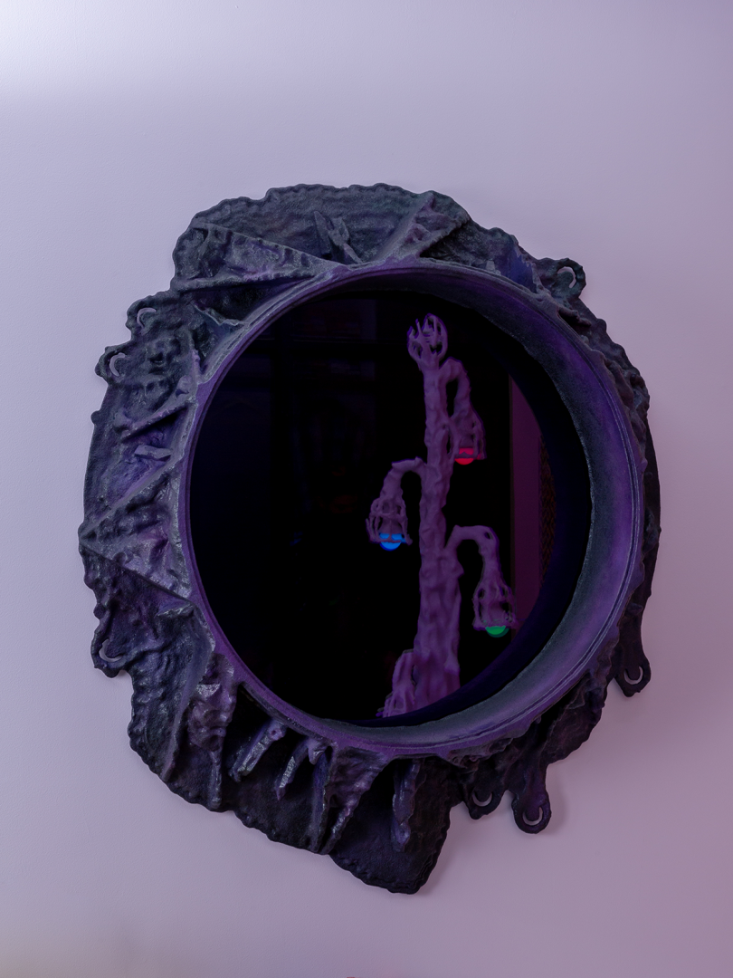 round purple-black mirror with amorphous frame on light purple wall