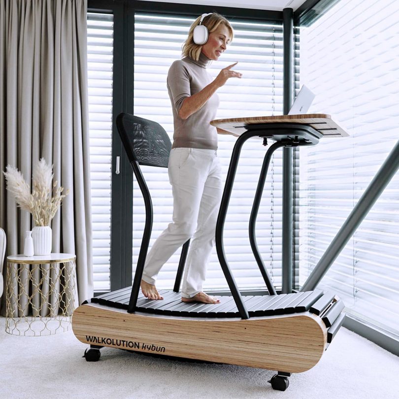 woman walking on treadmill workstation in front of large windows
