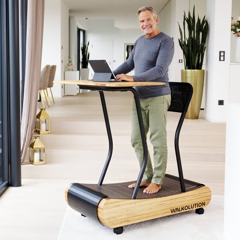 man standing on treadmill workstation in living space