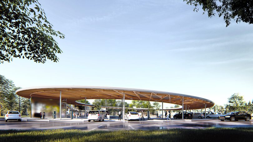 Side view render of a circular charging station, with cars parked on the outside, and guests are invited into an inner courtyard in the middle. 
