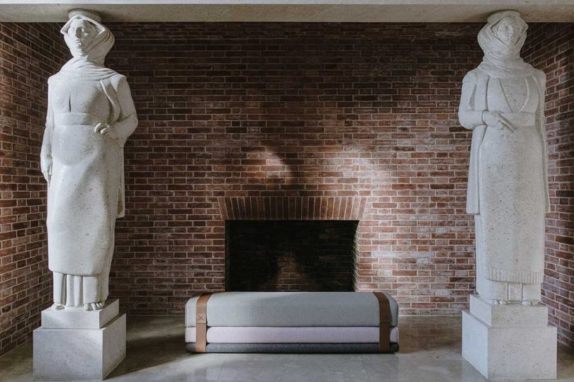 upholstered settee between two marble statues