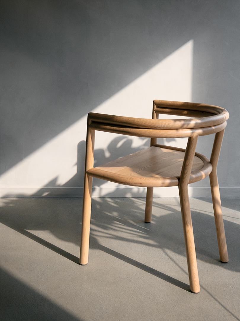 side view of curved wood armchair