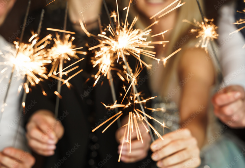 four outstretched arms holding lit sparklers