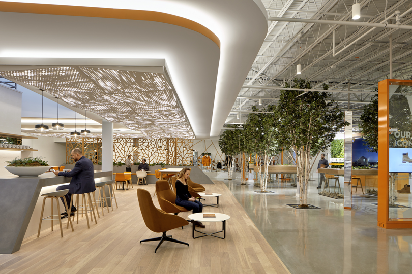 interior office space with high ceilings, dramatic overhead lighting, trees, and sitting areas
