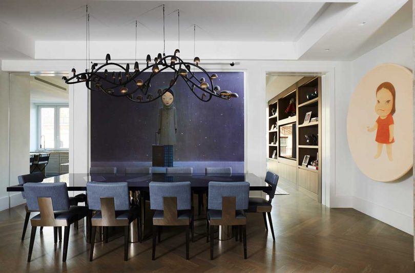 dining space with dark dining table, dining chairs, chandelier, and art