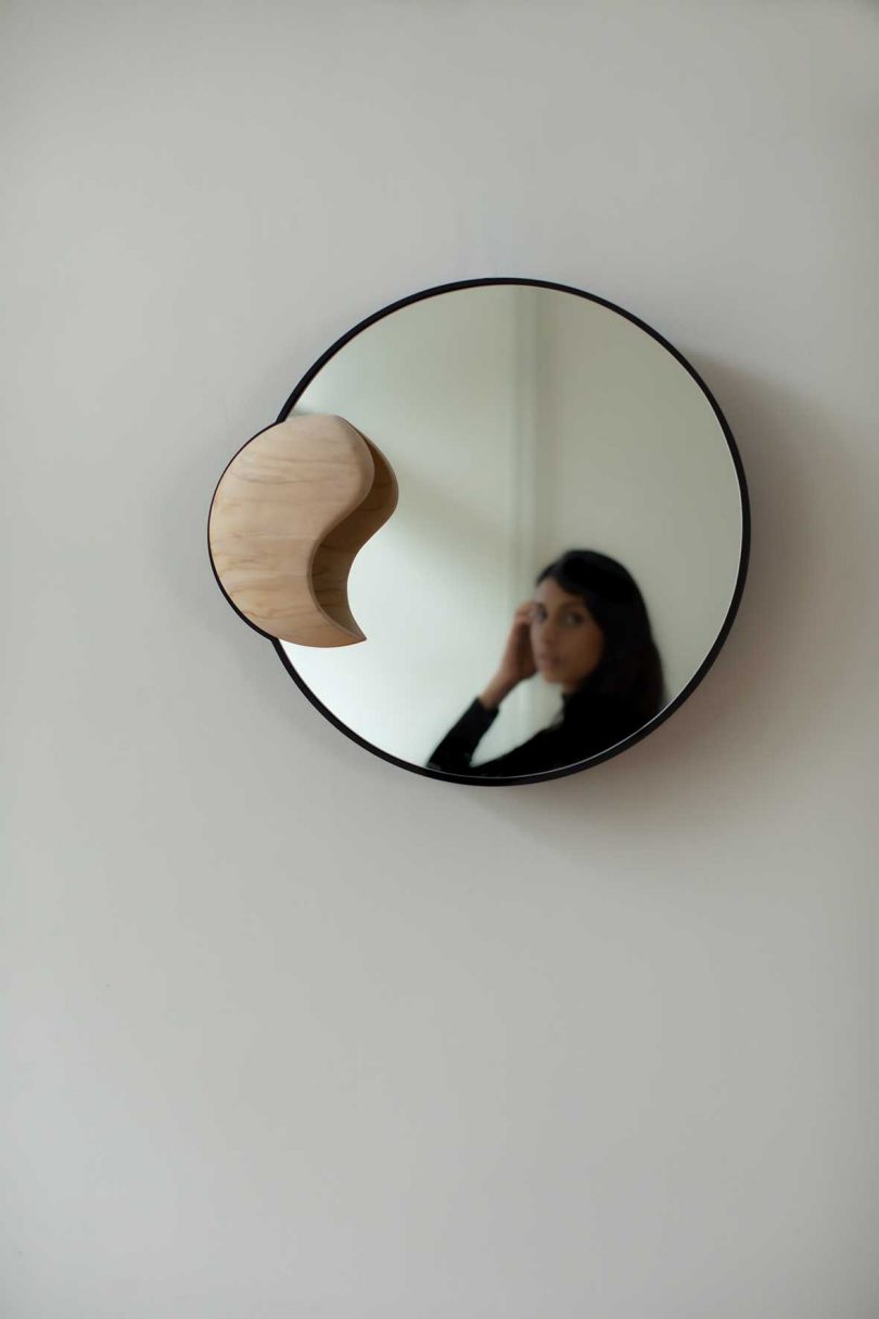 round mirror reflecting a person