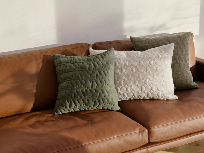 two pillows on a brown leather couch