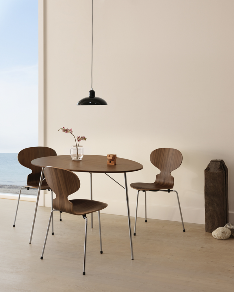egg shaped table and three chairs with black pendant light