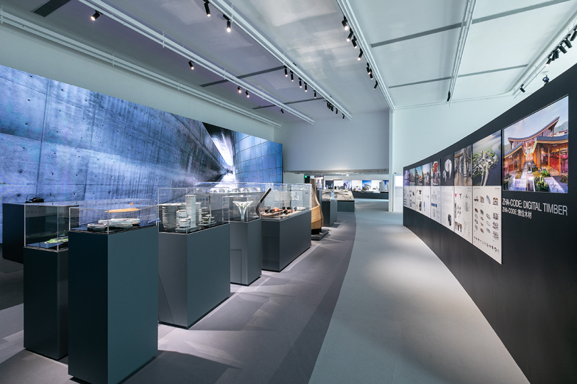 exhibition space with dark grey pedestals holding architectural models
