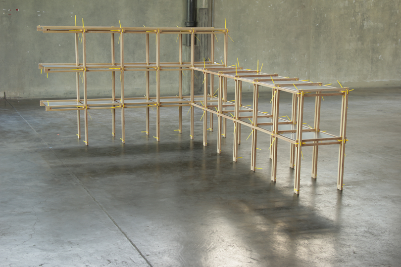 skeletal wood furniture system in an empty warehouse