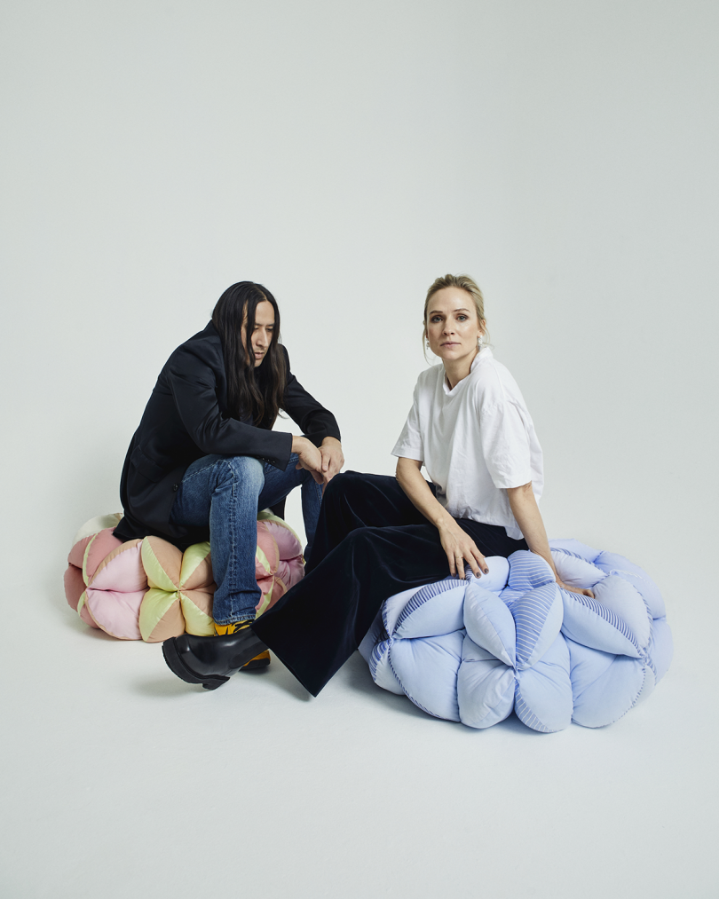 two people sitting on top of two poufs