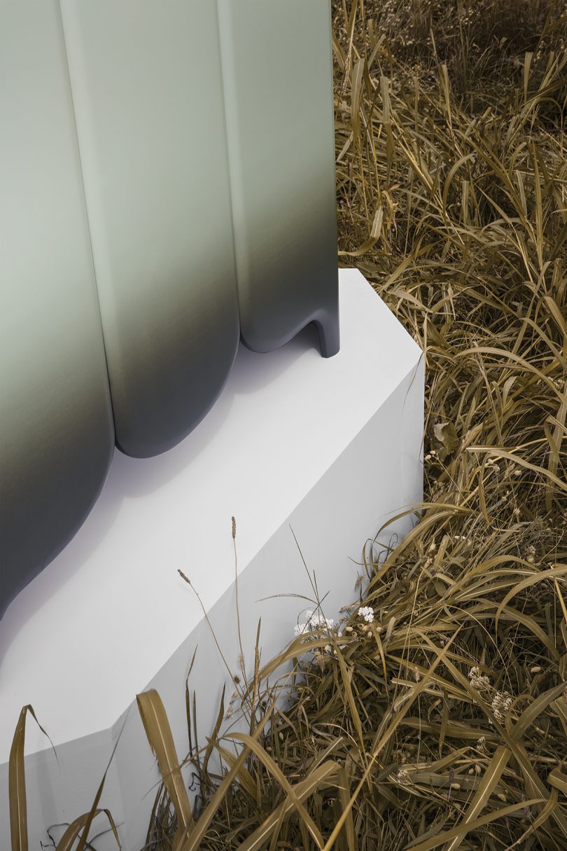 detail of black and grey gradient sideboard on a pedestal in a field