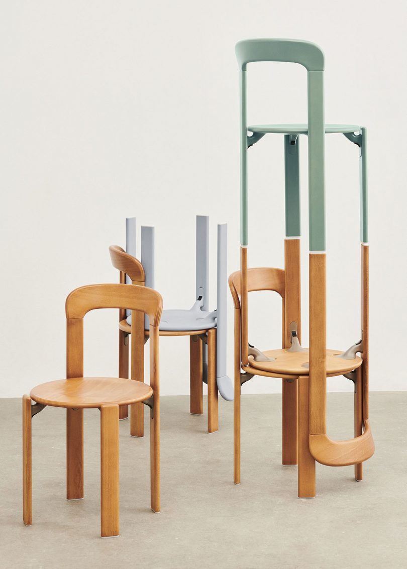 light grey enamel and beech wood chairs stacked balanced on one another