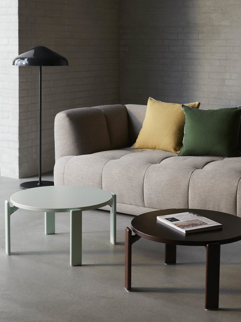 two round coffee tables in front of a light grey couch with two throw pillows