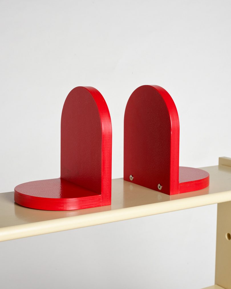 two red bookends on natural wood colored shelf