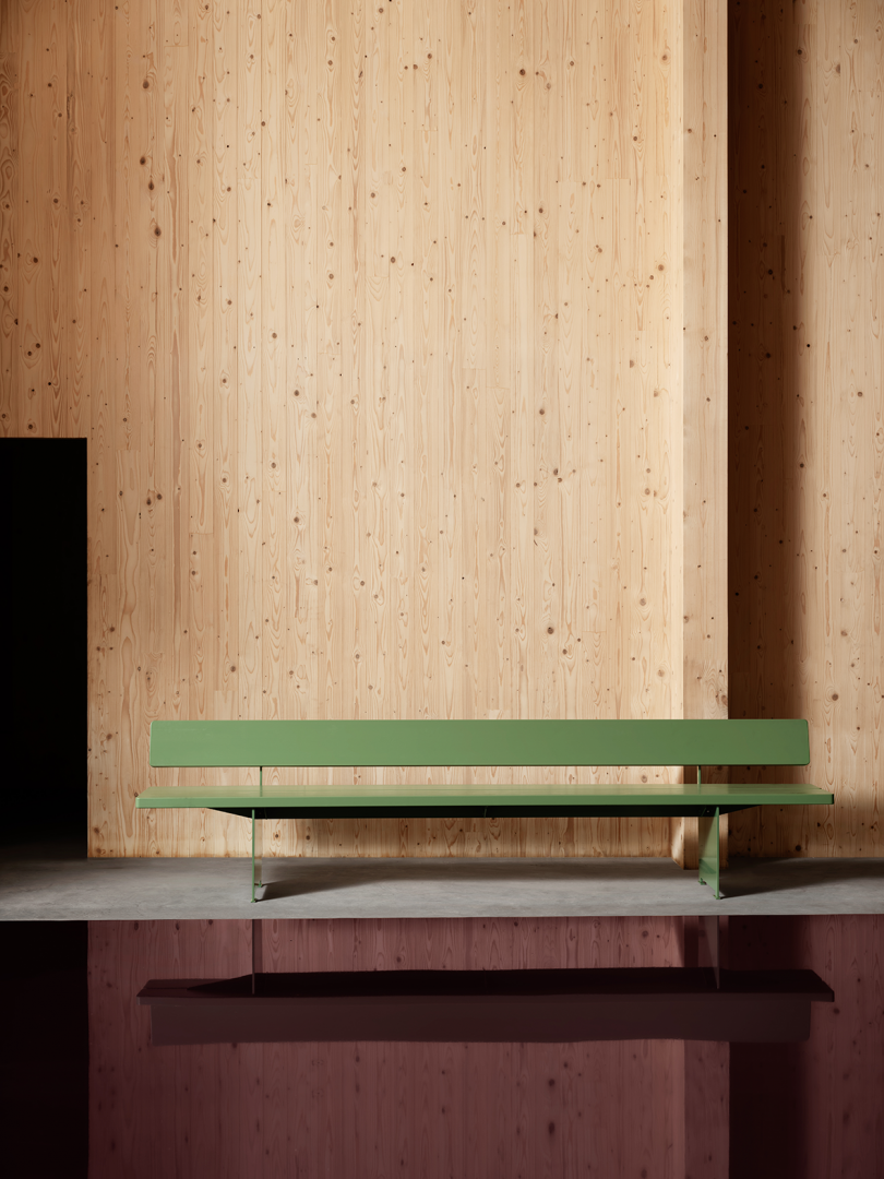 long light green bench in front of light wood wall