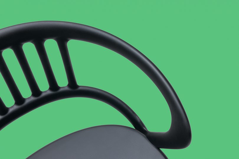 detail of black armchair on green background